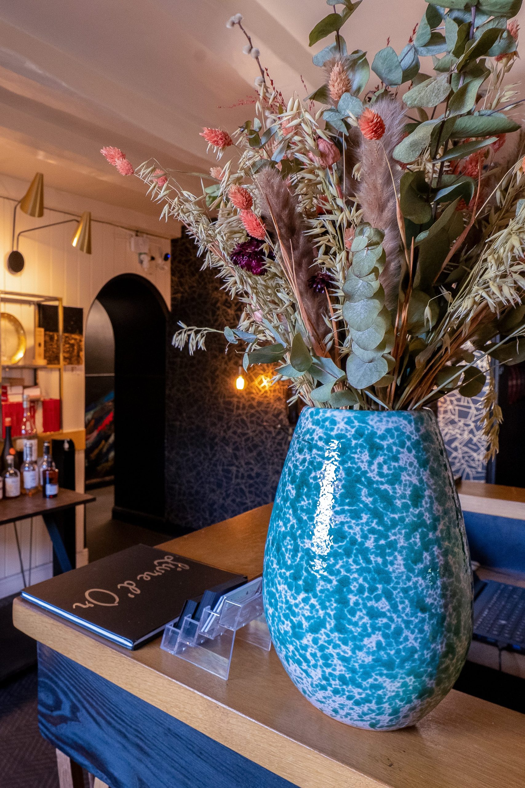 Vase bleu et bouquet de fleurs séchées dans la salle