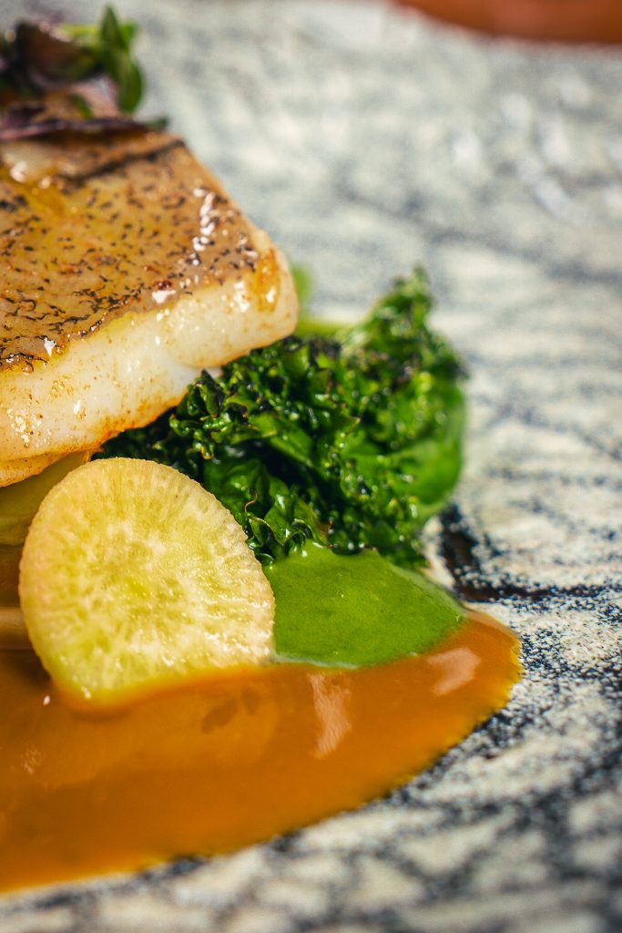 Poisson à la peau croustillante, légumes et sauce